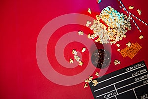 Cinema concept. Clapperboard, ticket and popcorn on red background