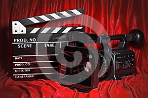 Cinema concept. Movie camera with clapperboard on the red fabric, 3D rendering