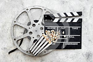 Cinema concept. Popcorn with film reel strip and clapper board