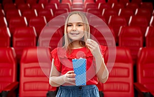 Smiling girl eating popcorn at movie theater