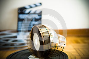 Cinema film reel and out of focus movie clapper board