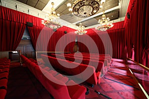 Cinema hall with chandeliers and rows of seats photo