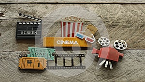 Cinema sign with popcorn bucket movie projector on wood background