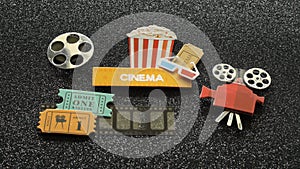 Cinema sign with popcorn bucket movie tickets on film strip all on black sparkled background