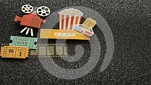 Cinema sign with popcorn bucket movie tickets on film strip all on black sparkled background photo