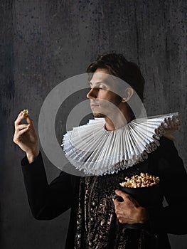 Cinema spectator of the Renaissance, a man in a medieval collar eats popcorn,