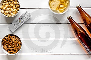 cinema and TV whatching with beer, crumbs, chips and pop corn white wooden background top view mock-up