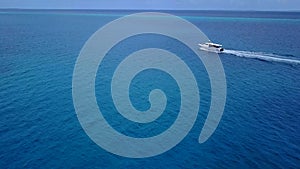 Cinemagraph of boating in the tropics. Indian ocean. Boat go from island. maldives. Water transport. Aerial shot.