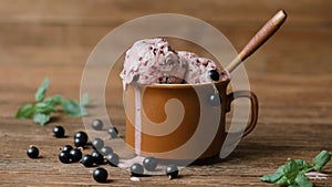 Cinemagraph - Currant ice cream in a cup on wooden table.