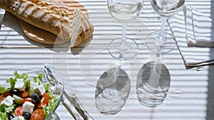 Cinemagraph - Greek salad and two glasses of white wine.