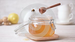 Cinemagraph - Honey pouring in a jar. Bee flying.