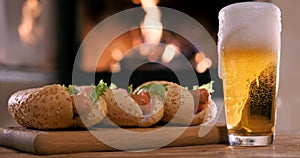 Cinemagraph - Hotdogs with beer on the fireplace background.
