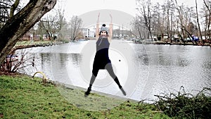 Cinemagraph of jumping young woman in front of lake