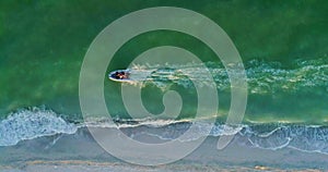 Cinemagraph. Motor boat travels at high speed along the sea shore. Aerial view.