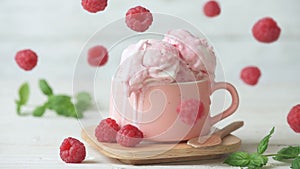 Cinemagraph - Raspberry ice cream in a cup on wooden table.