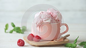 Cinemagraph - Raspberry ice cream in a cup on wooden table.