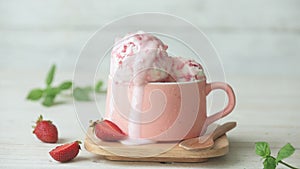 Cinemagraph - Raspberry ice cream in a cup on wooden table.