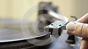 Cinemagraph retro style memories female hand holding old recorder needle to put on vinyl plate spinning