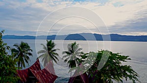Cinemagraph of Toba Lake in Sunny Weather with Traditional Batak Style Roofs from Samosir Island, North Sumatra