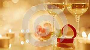 Cinemagraph - Two glasses with white wine and rose flower on bokeh background.