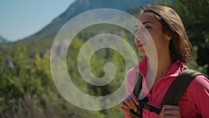 cinematic 4k slow motion attractive woman hiker walking outdoors in mountains with forest on background, happy girl