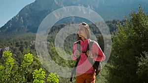 cinematic 4k slow motion attractive woman hiker walking outdoors in mountains with forest on background, happy girl