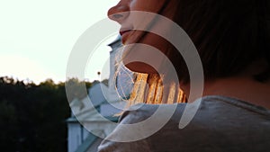 Cinematic close-up of beautiful and thoughtful female. Wind flutters hair of young woman in front of orthodox church.