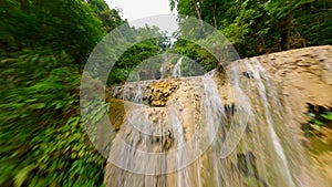 Cinematic FPV drone flight over tropical Kuang Si Waterfall in Laos