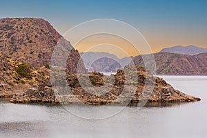 Cinematic lake surrounded by red cliffs in Provincia de Mendoza, Argentina photo