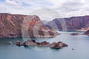 Cinematic lake surrounded by red cliffs in Provincia de Mendoza, Argentina photo