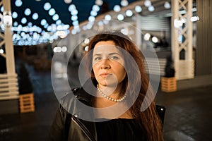 Cinematic night portrait of girl and lights in city with copy space - night life and youth concept