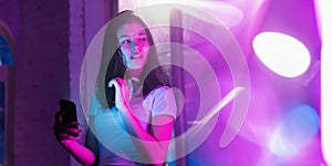 Cinematic portrait of handsome young woman in neon lighted interior