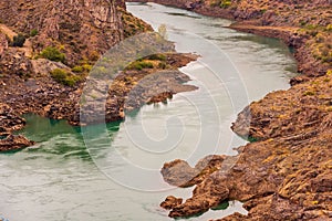 Cinematic river surrounded by red cliffs in Provincia de Mendoza, Argentina photo