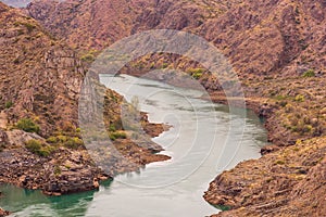 Cinematic river surrounded by red cliffs in Provincia de Mendoza, Argentina photo