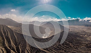 Cinematic shot aerial view of Mount Bromo crater with active volcano smoke in East Java