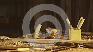 Cinematic shot of table with tools in the garage. Professional carpenter tools, equipment and wooden materials laying on