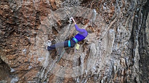 cinematic slow motion footage of strong female climber climbing very hard overhang route making hard moves.