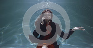 Cinematic under water portrait of happy young mixed race business woman in office suit talking on phone slow motion.