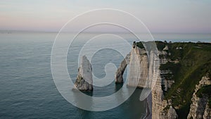 Cinematic view of beautiful cliffs by Etretat in France on background of beautiful sea scenery during sunset on seacoast