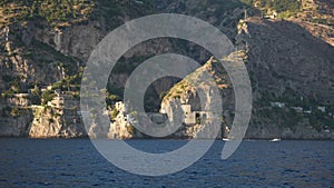 Cinematic view of Furore fjord from sea on boat on Amalfi Coast. Ferry traveling towards Amalfi coast in Campania, Italy