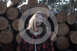 Cinematics portrait of a girl against the background of felled trees, the concept of mourning for the destroyed forest.