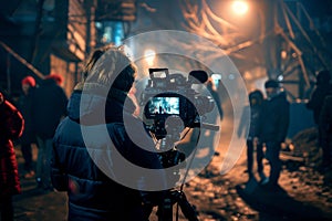Cinematographer filming a night scene on urban street