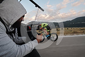 Cinematographer taking action shot of triathlon bike athlete