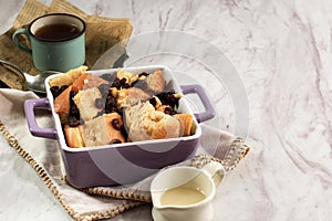 Cinnamon Bread and Butter Pudding with Raisins in Purple Square Baking Dish. Copy Space  for Text or Advertisement