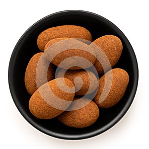 Cinnamon and chocolate coated almonds in a bowl isolated