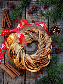 Cinnamon cocoa brown sugar wreath buns. Sweet Homemade christmas baking. Roll bread, spices, decoration on wooden background. New