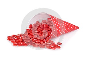 Cinnamon hearts spilling from red heart cone