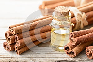 Cinnamon oil and cinnamon sticks on the wooden board