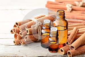 Cinnamon oil and cinnamon sticks on the wooden board