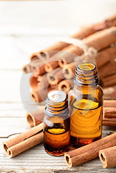 Cinnamon oil and cinnamon sticks on the wooden board